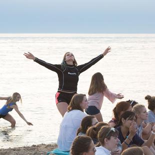 Students dancing on the beach and in the water