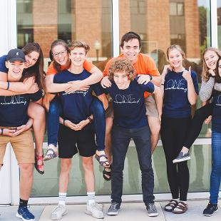 A group of students posing for a photo in piggy-back